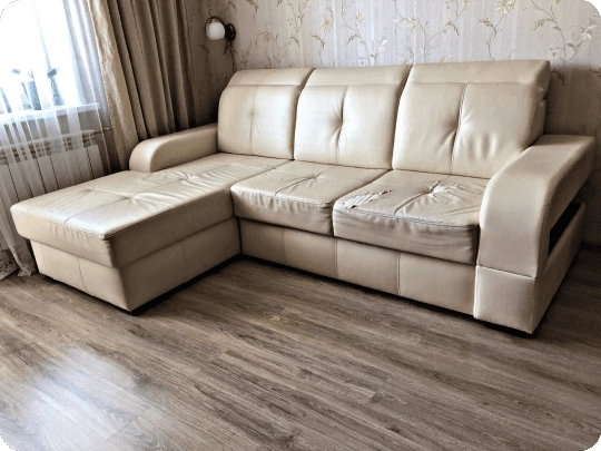 Cream leather corner sofa-bed with both seat cushions split open