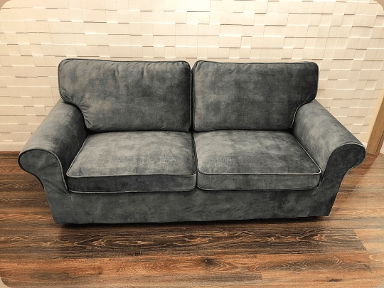The same loveseat recovered in grey velvet with contrast piping