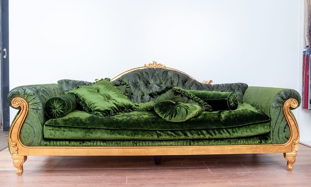 Giltwood scroll-arm sofa before restoration in slack green paisley cut-velvet