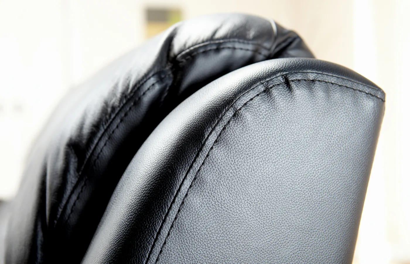 Custom cushions NYC: the rolled arm and seat of a finished black leather sofa, completed in Brooklyn
