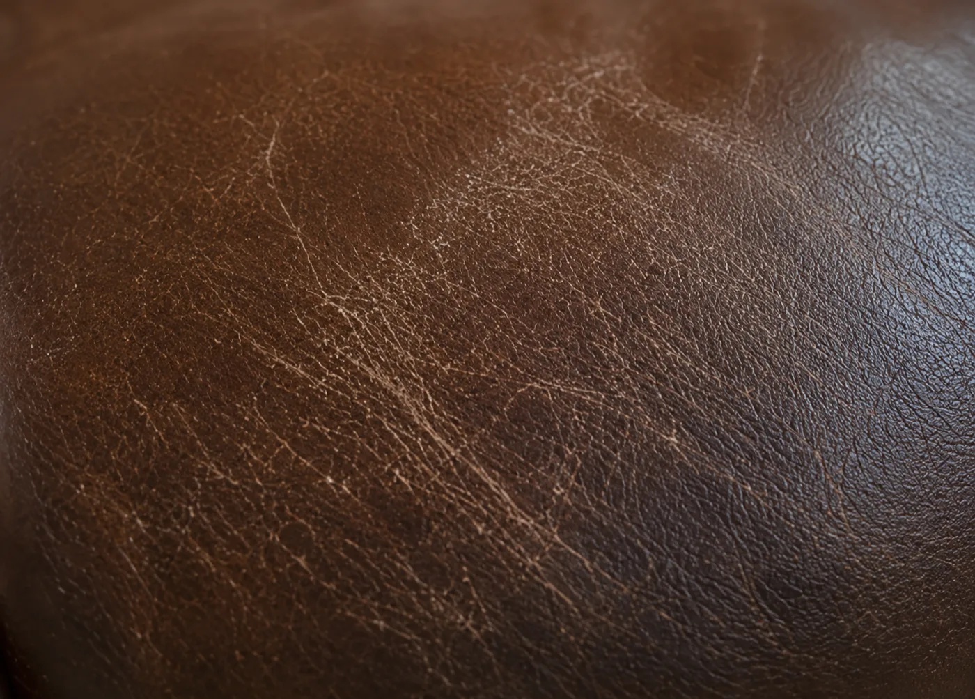 Fine crazing across the surface of a brown leather banquette back