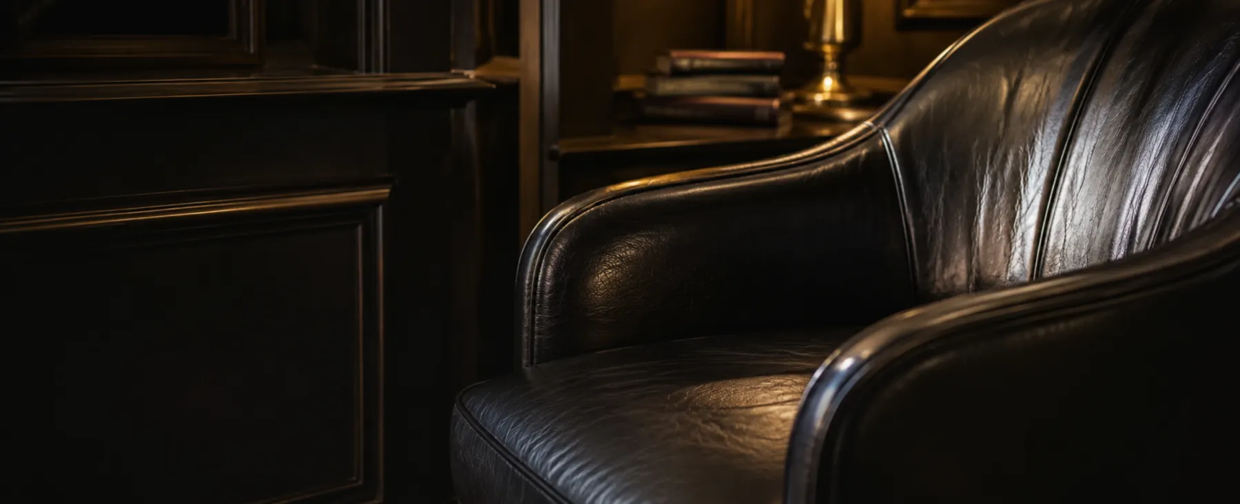 A black leather lounge chair in a dark hotel bar, the kind of commercial seating our commercial furniture repair capabilities are built around
