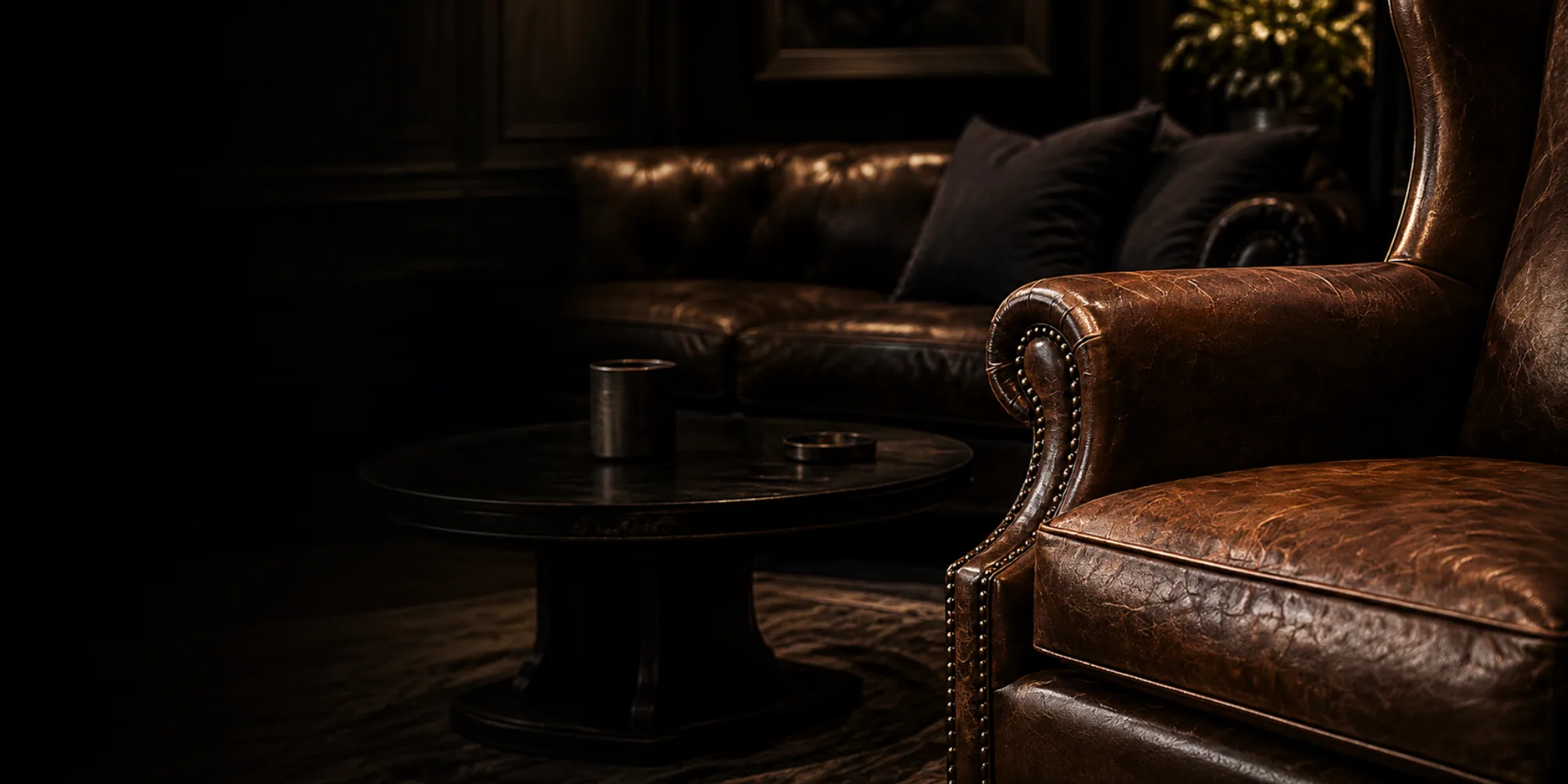 A brown leather armchair in a dark lounge