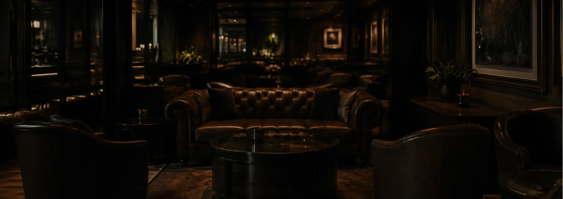 A dark leather lounge with tufted sofas and armchairs