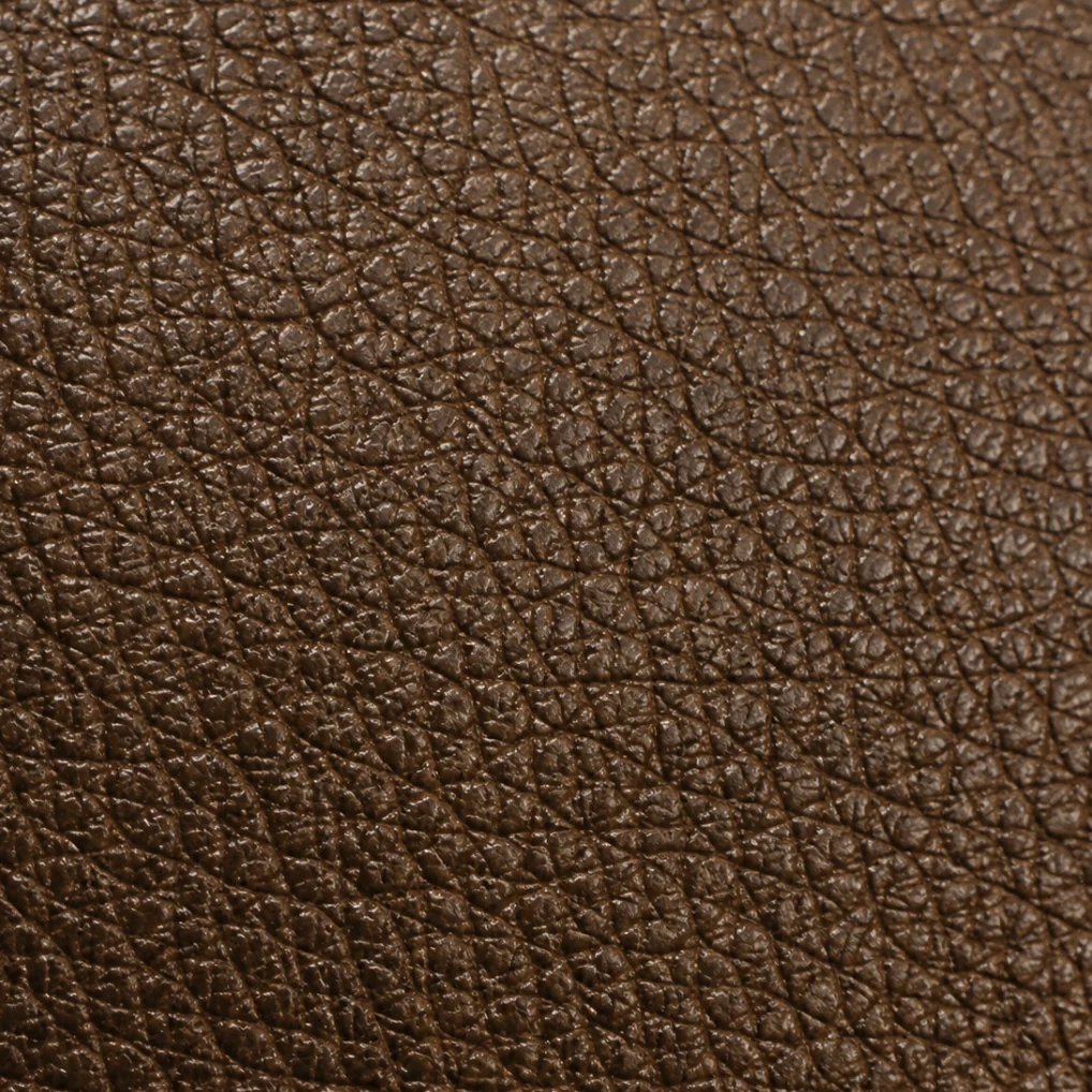 Close-up of pigmented leather, an even brown surface where the color sits on top of the grain