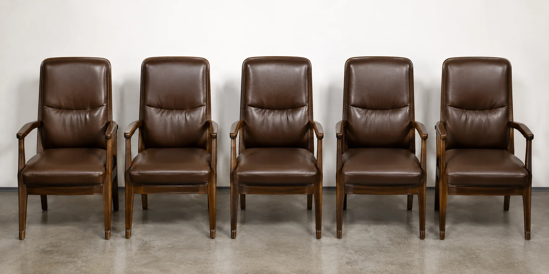 Row of matching brown leather office chairs after repair