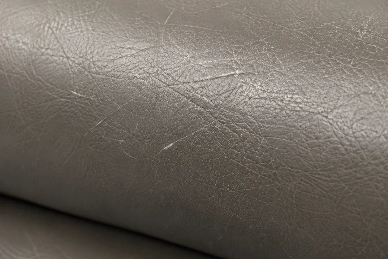 A gray leather seat roll gone dry and flat, its sheen scratched away