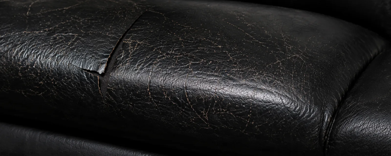 Black leather cushion with a peeling surface, before