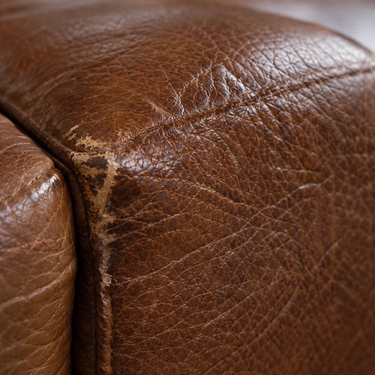 Abraded corner on the outer arm of a leather sectional