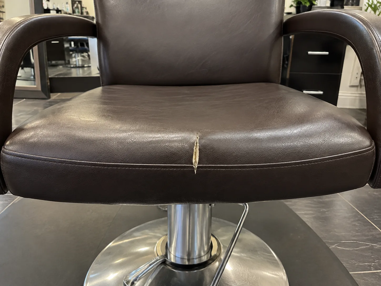 A split all-purpose salon chair seat before reupholstery