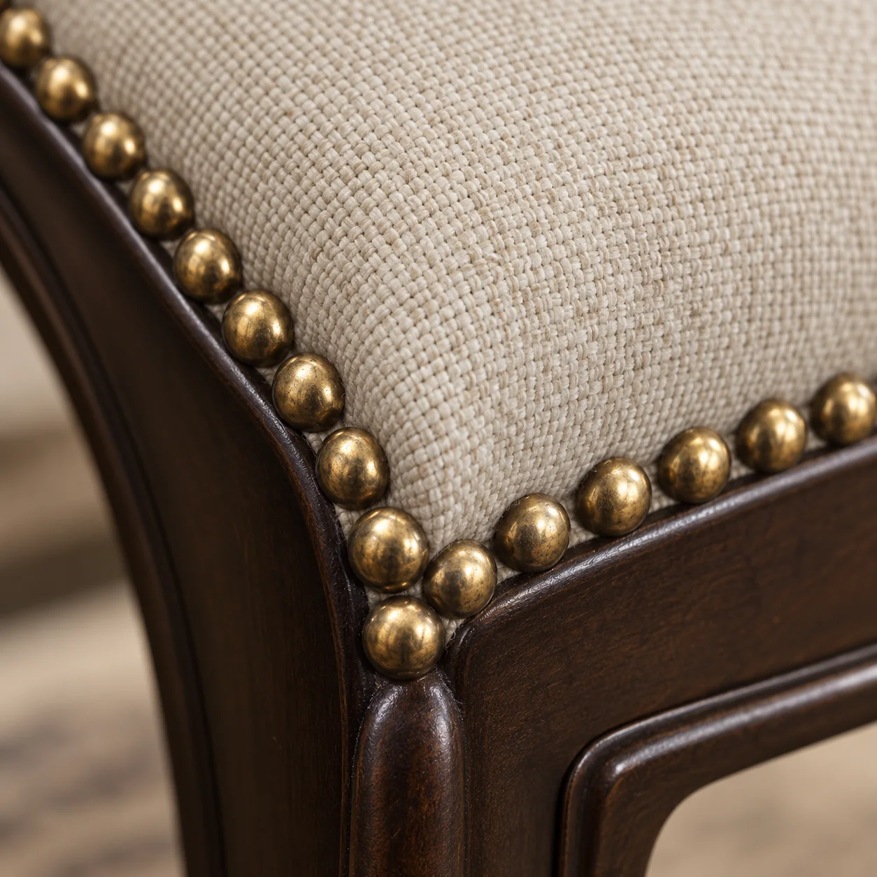 Antique brass nailhead trim set along a dining chair edge