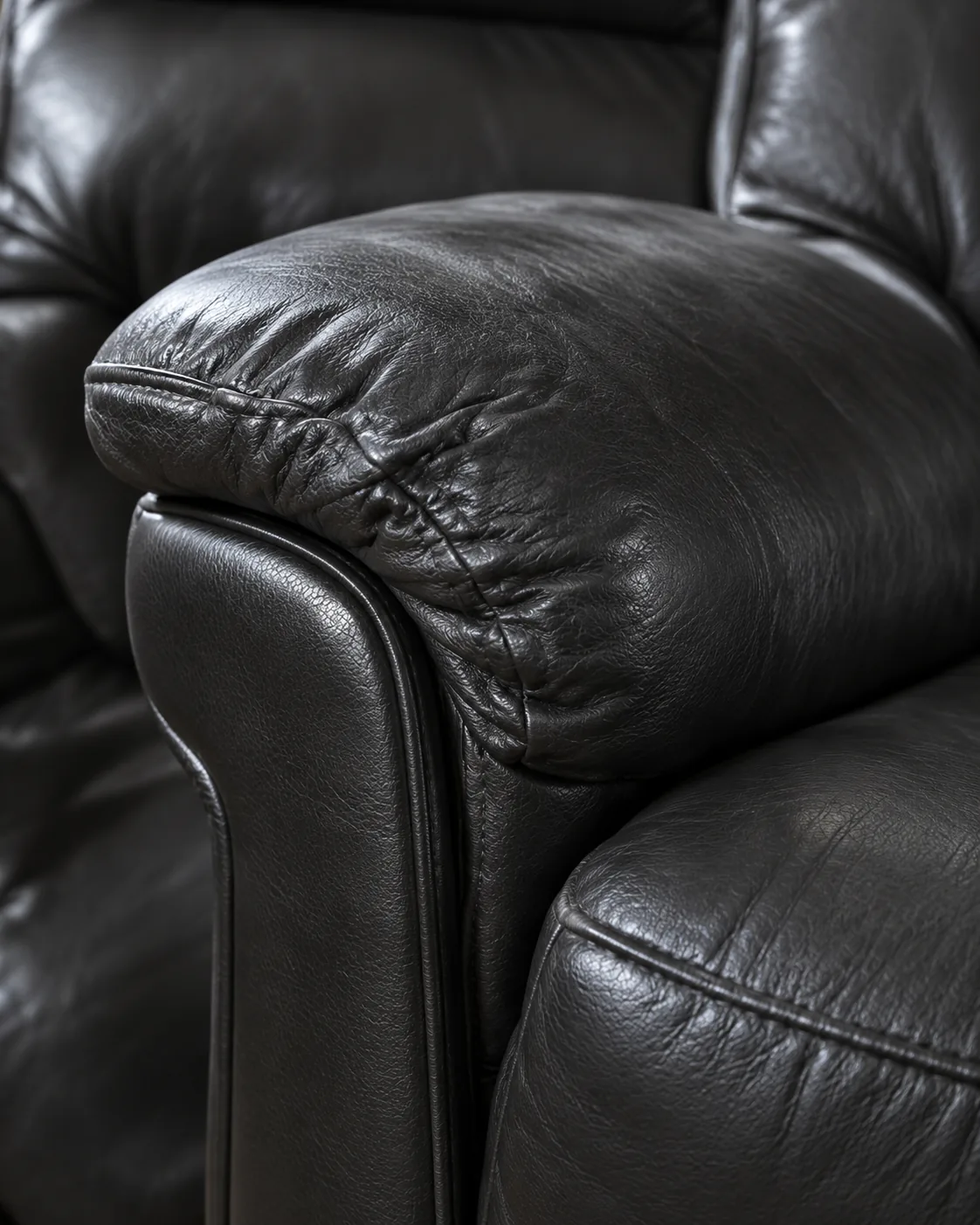 Creased top of a black recliner arm