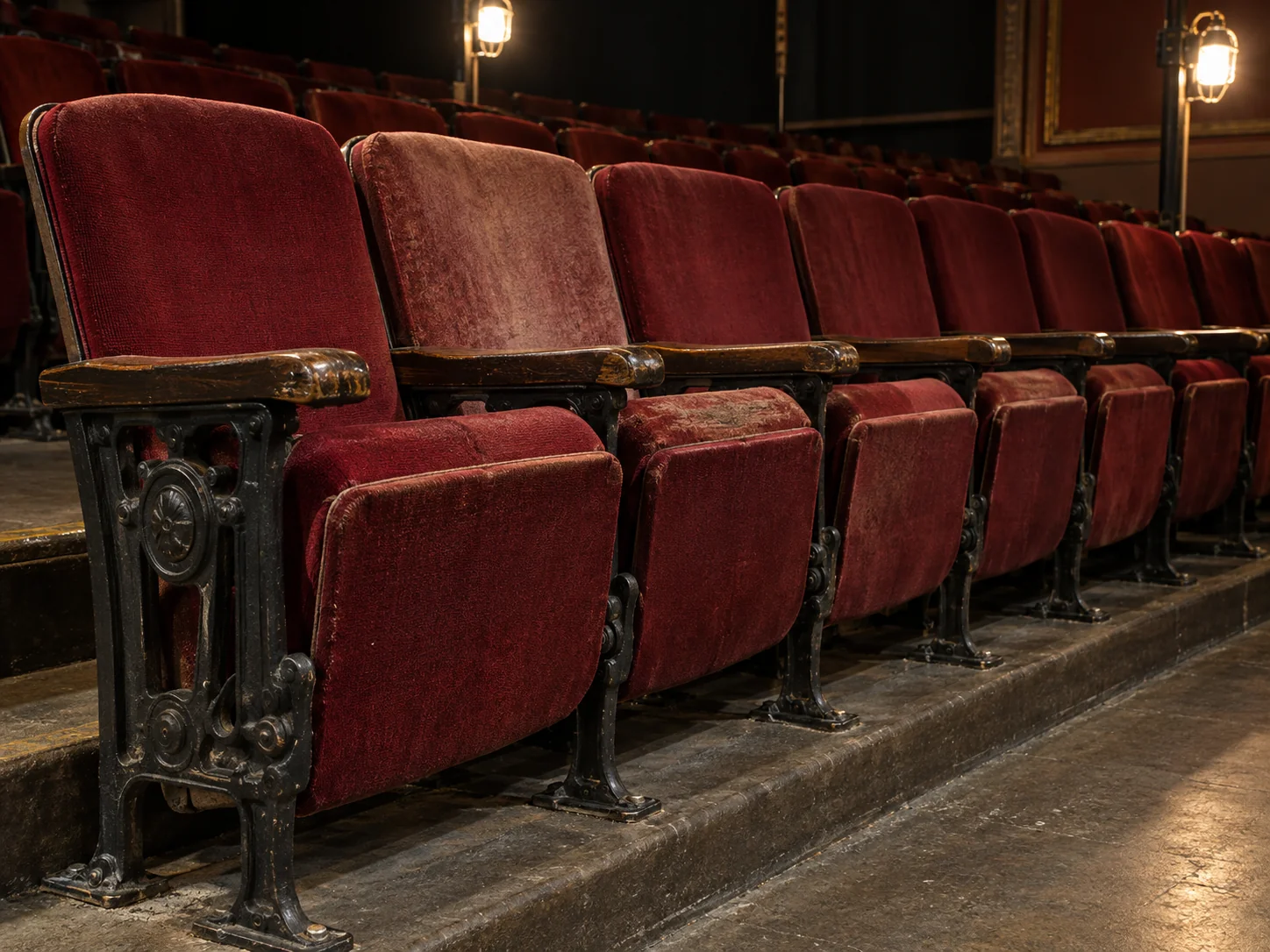 Before: a row of auditorium seats with mismatched, worn fabric