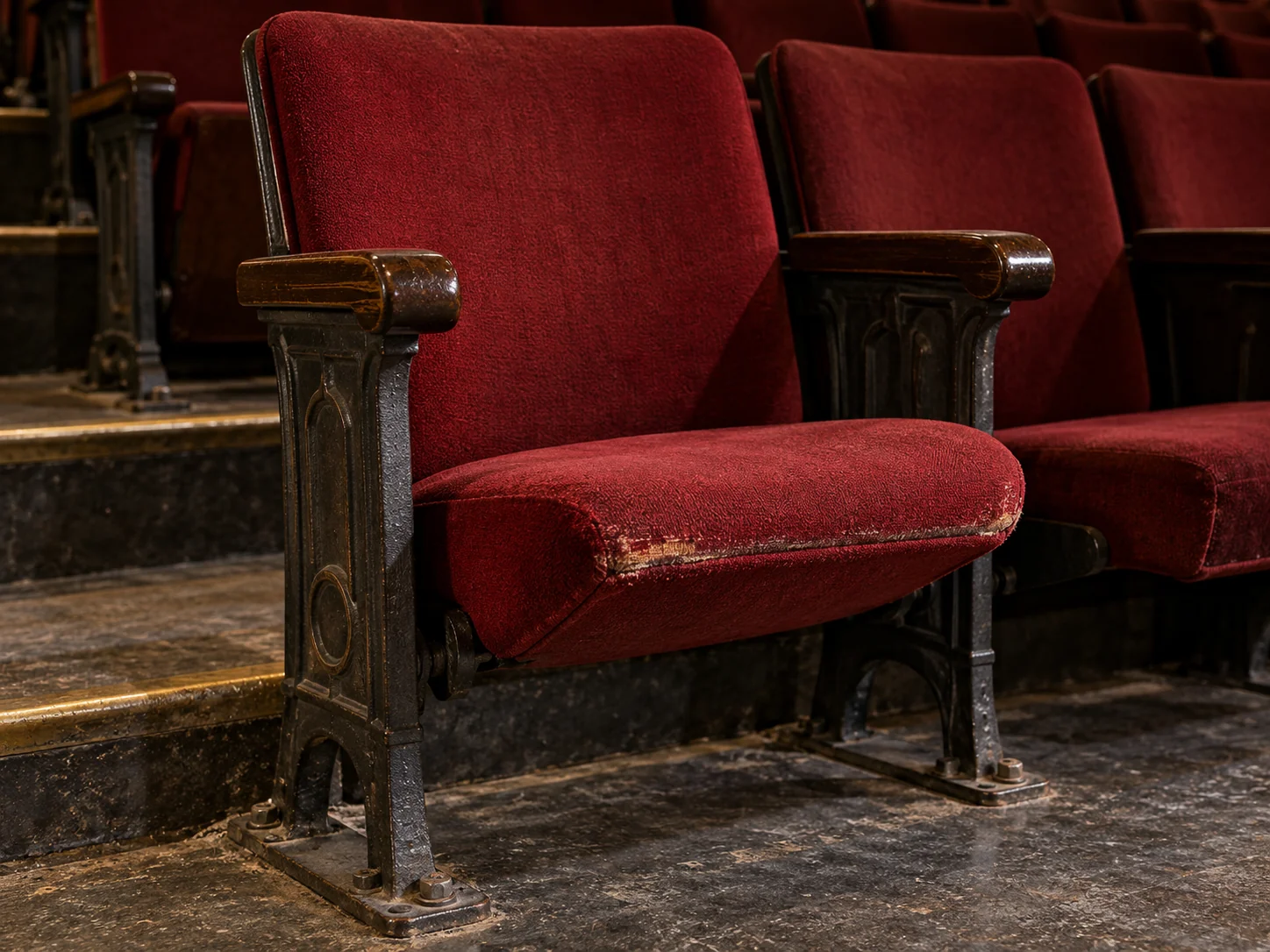 Before: an auditorium seat with fabric worn through at the front edge