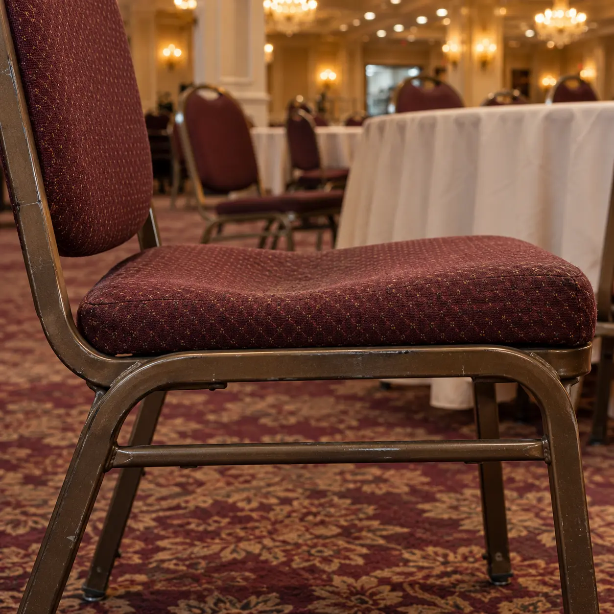 A flattened, dished banquet chair seat seen from the side