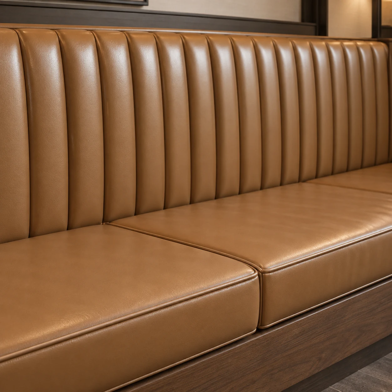 Tan leather banquette with plain seat pads under a channelled back