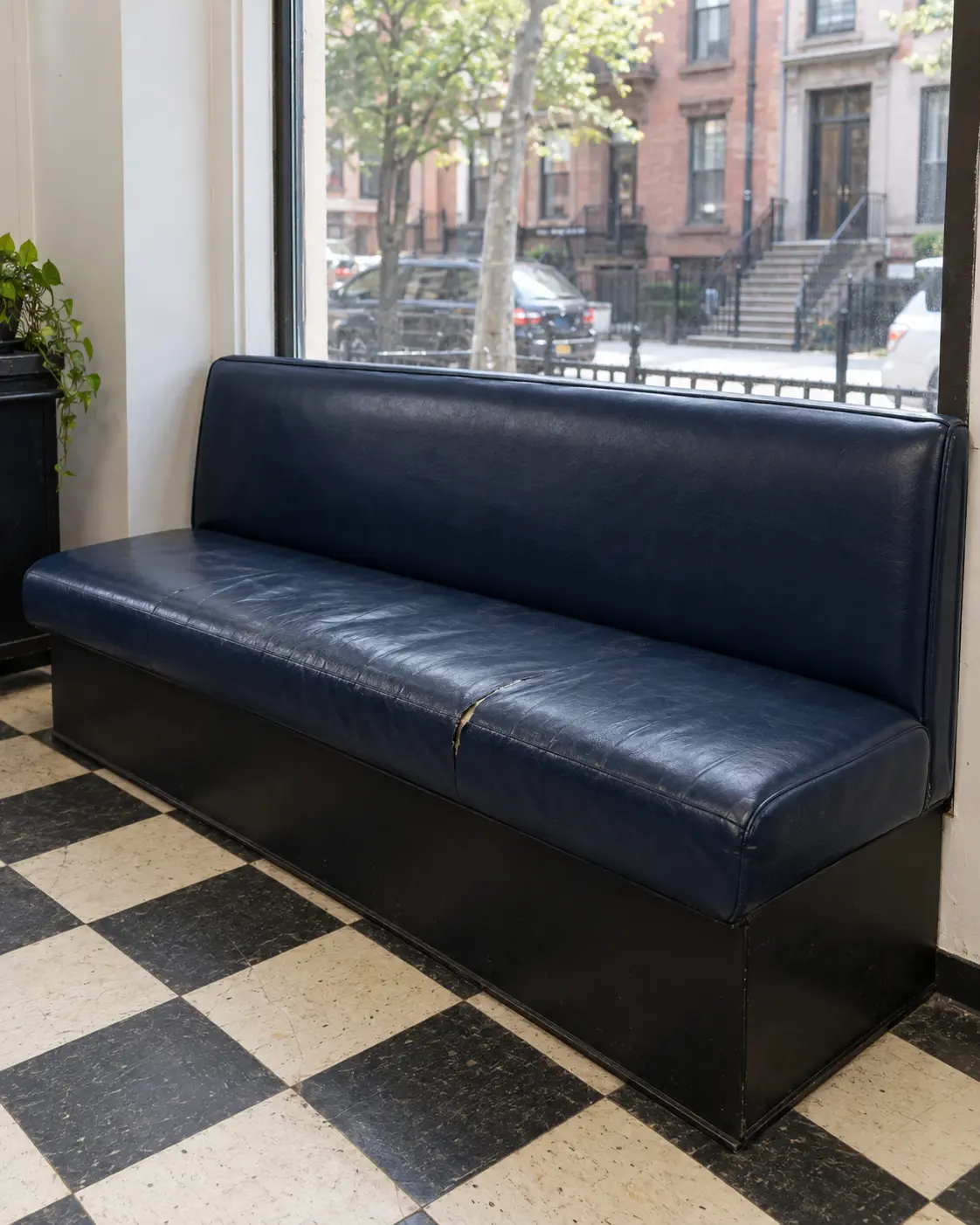 A navy barbershop waiting bench with a split, flattened seat