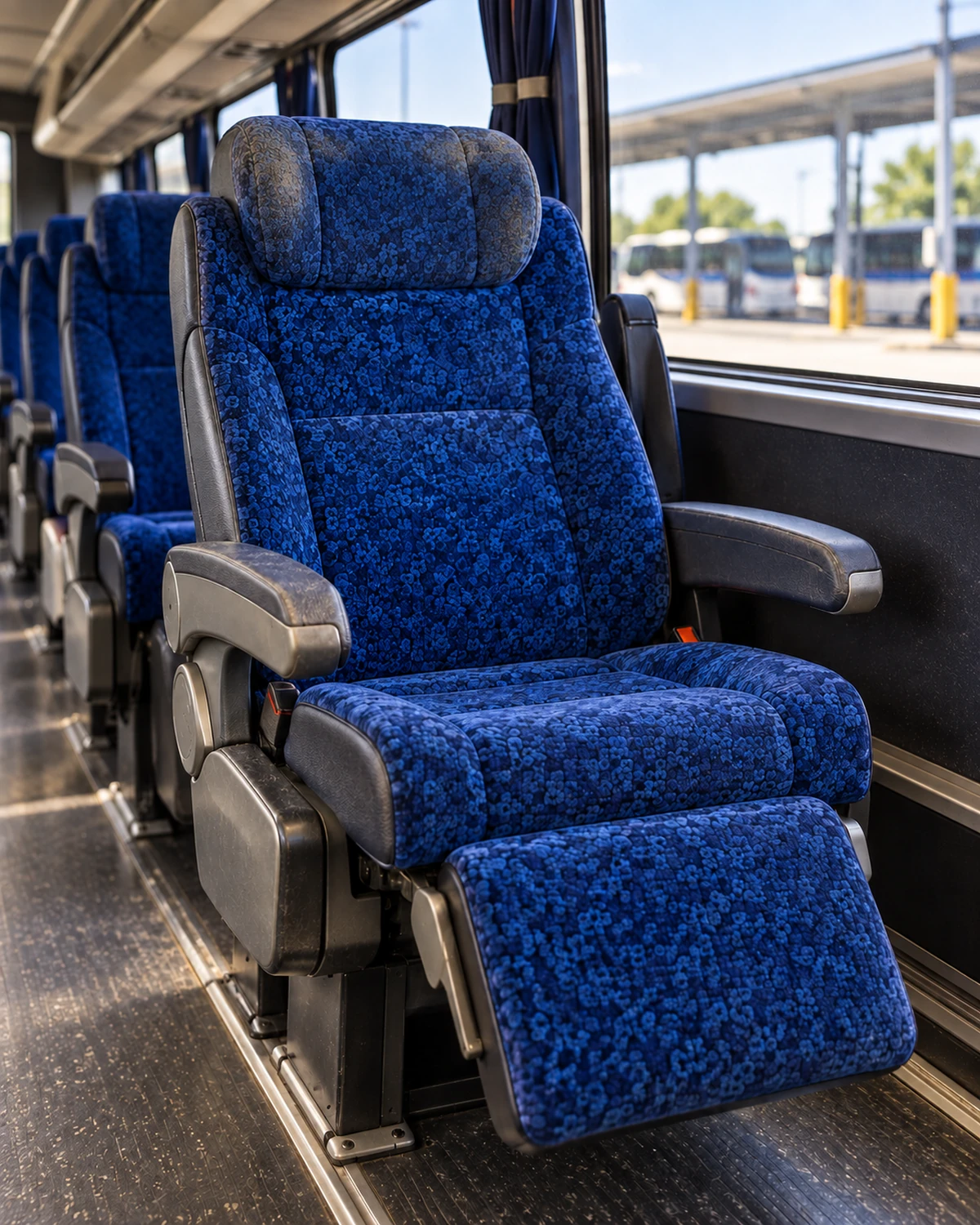 A motorcoach seat with a worn, dirty headrest and back