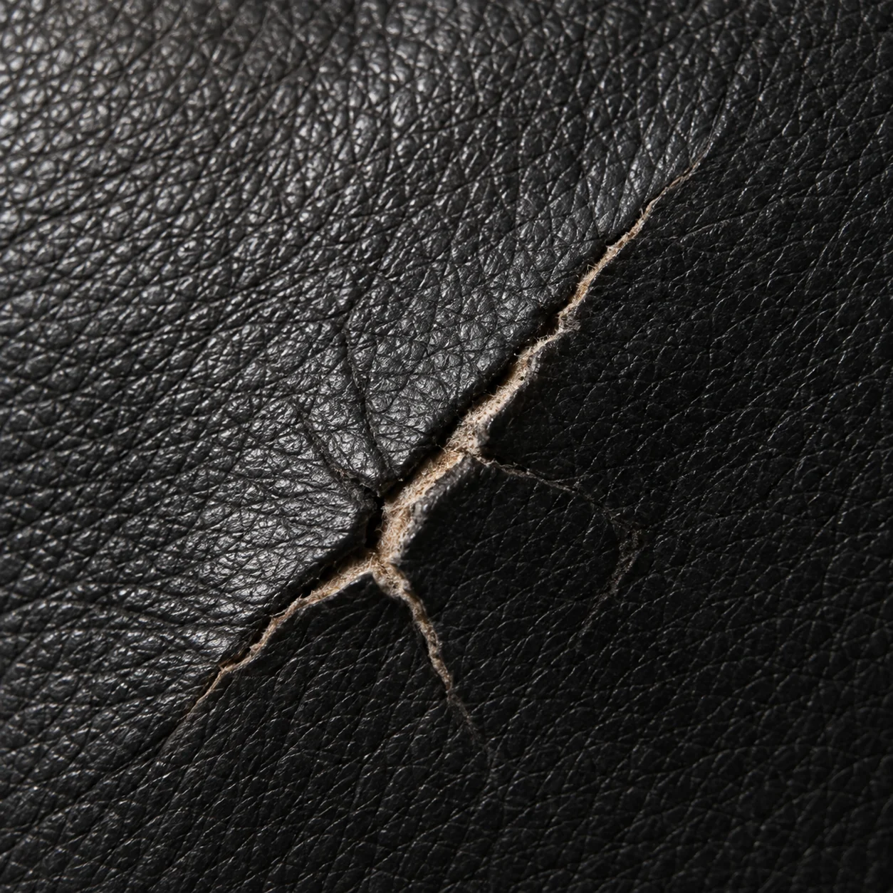 Crack through black leather to the fibers