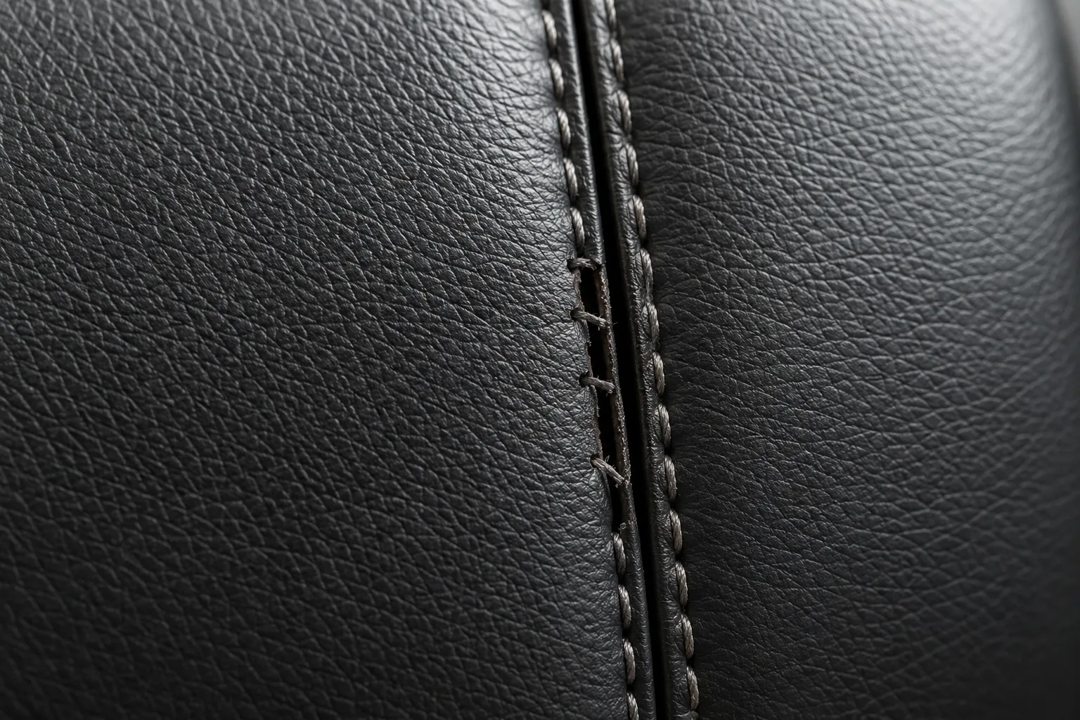 Close-up of a piped seam in black office chair leather