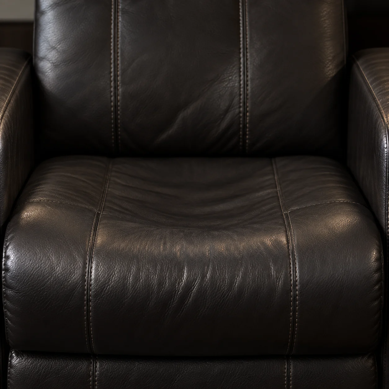 Black home theater seat holding a deep body print across the cushion and back