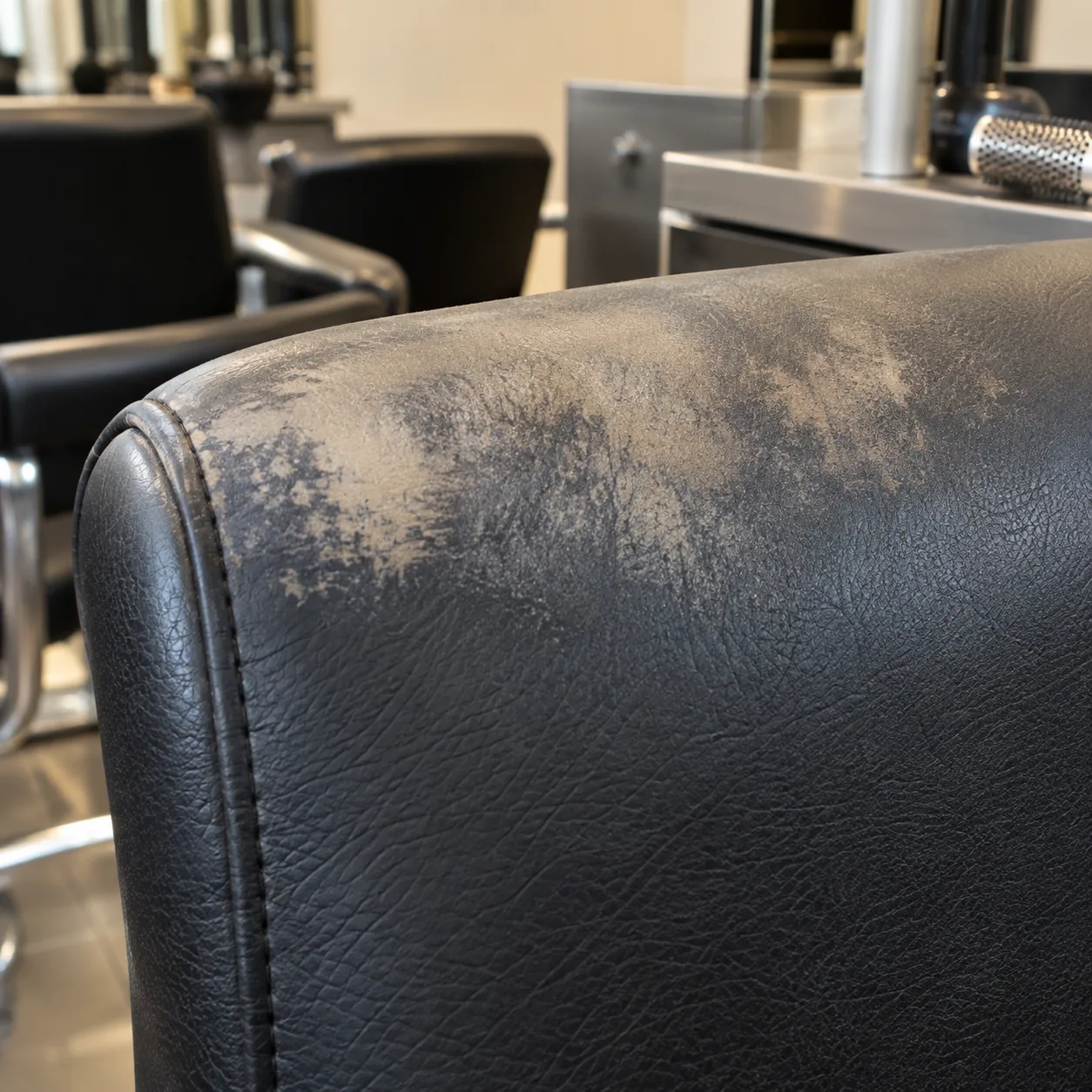 Patchy bleach fade on a dark salon chair back