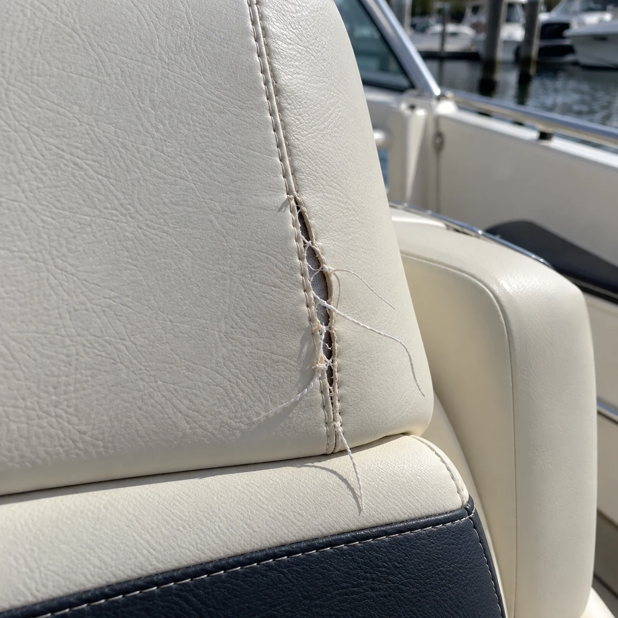 A run of stitching opened along a boat seat panel join