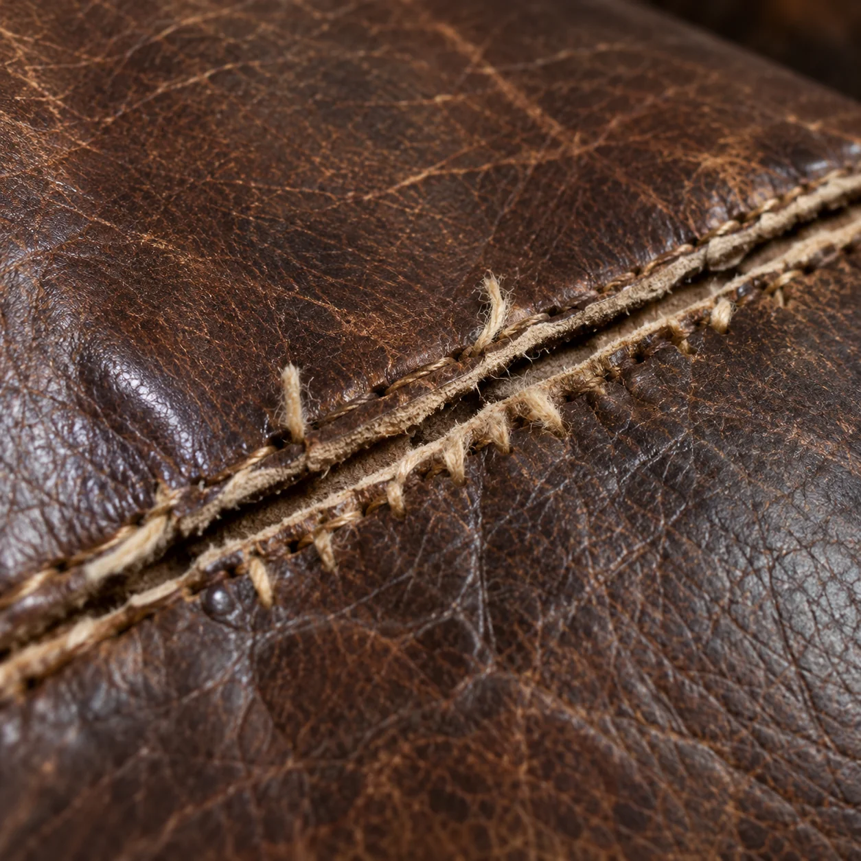 Broken stitching leaving a seam gaping on an antique leather sofa
