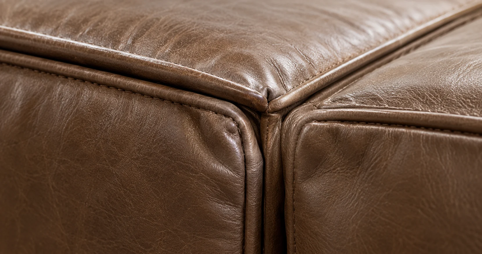 Sound corner of a brown leather bed where the seams of two panels converge