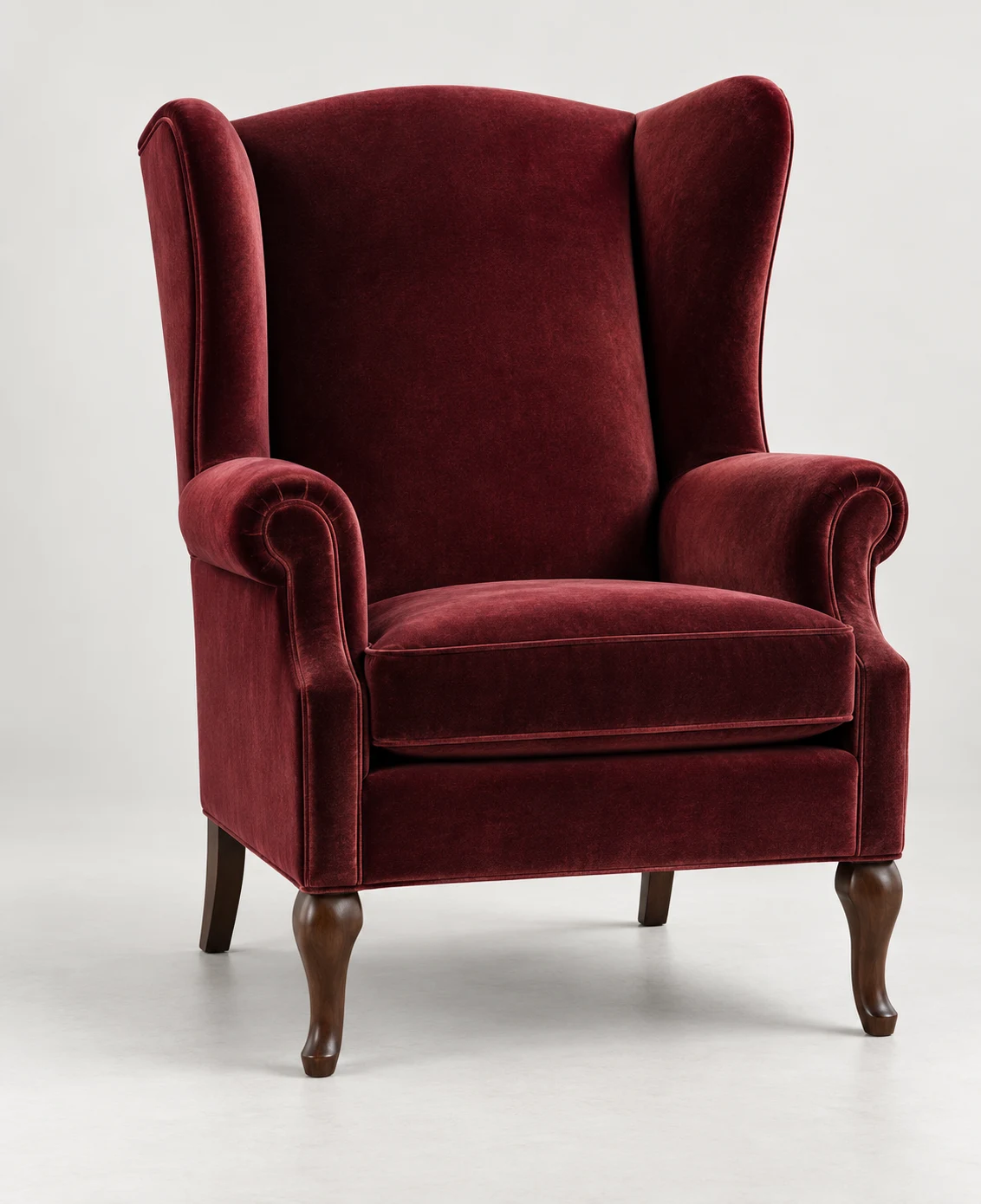 Burgundy velvet wingback chair with rolled arms and turned front legs