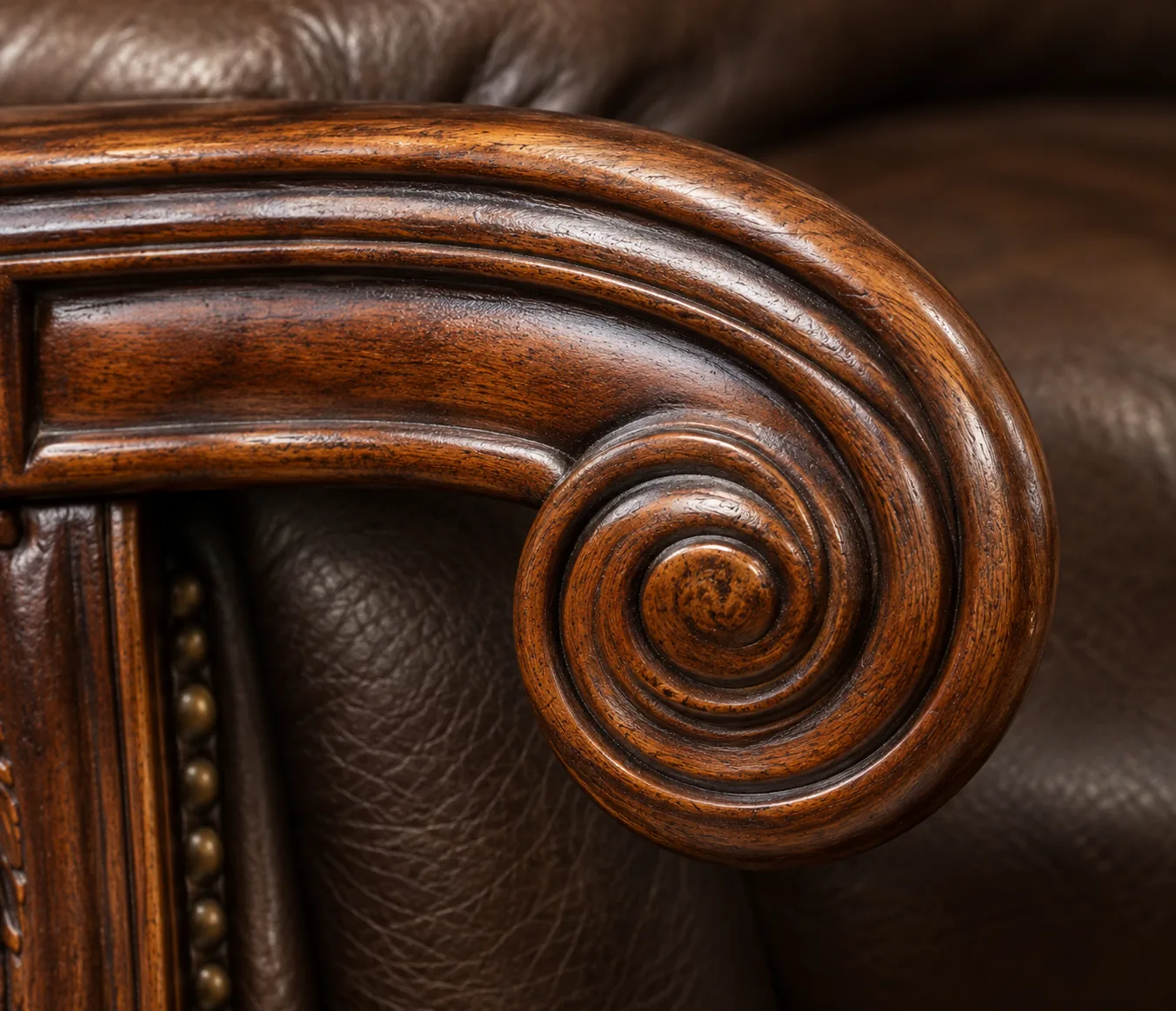 Carved wood scroll arm on an antique leather chair