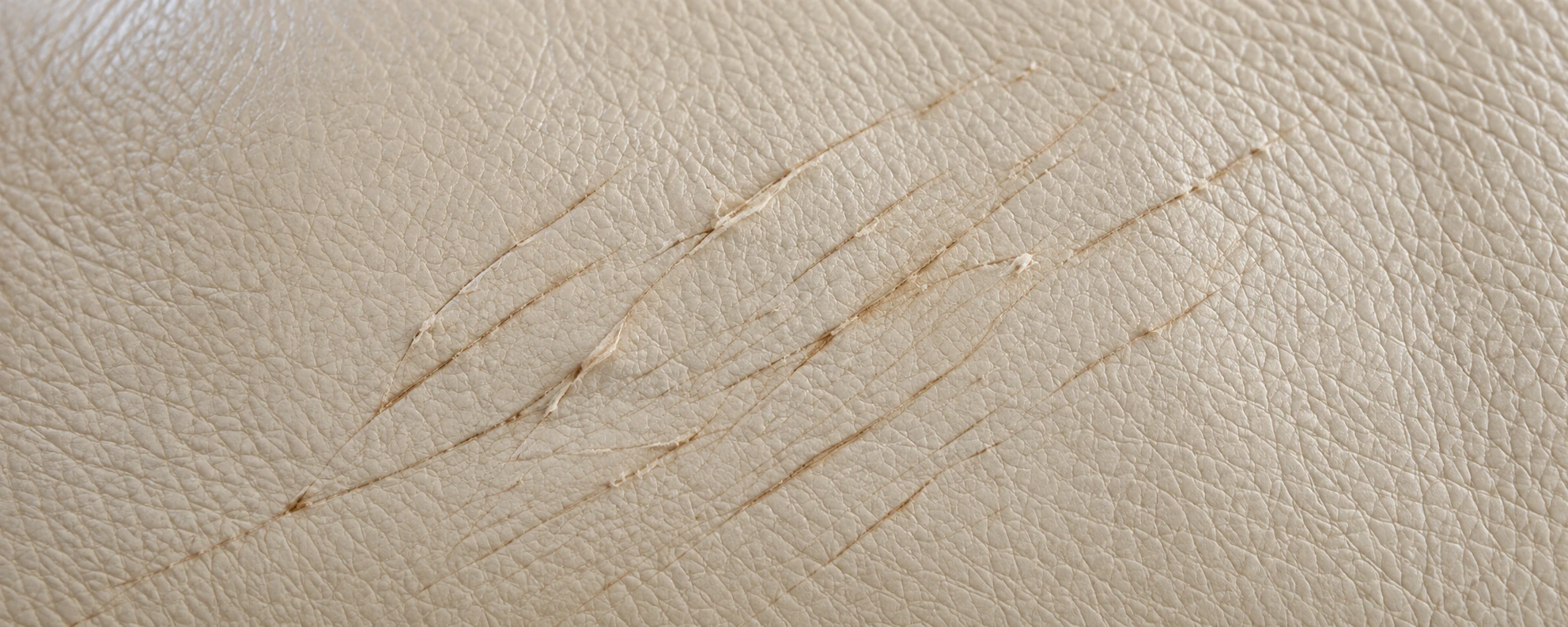 Scratches across cream leather