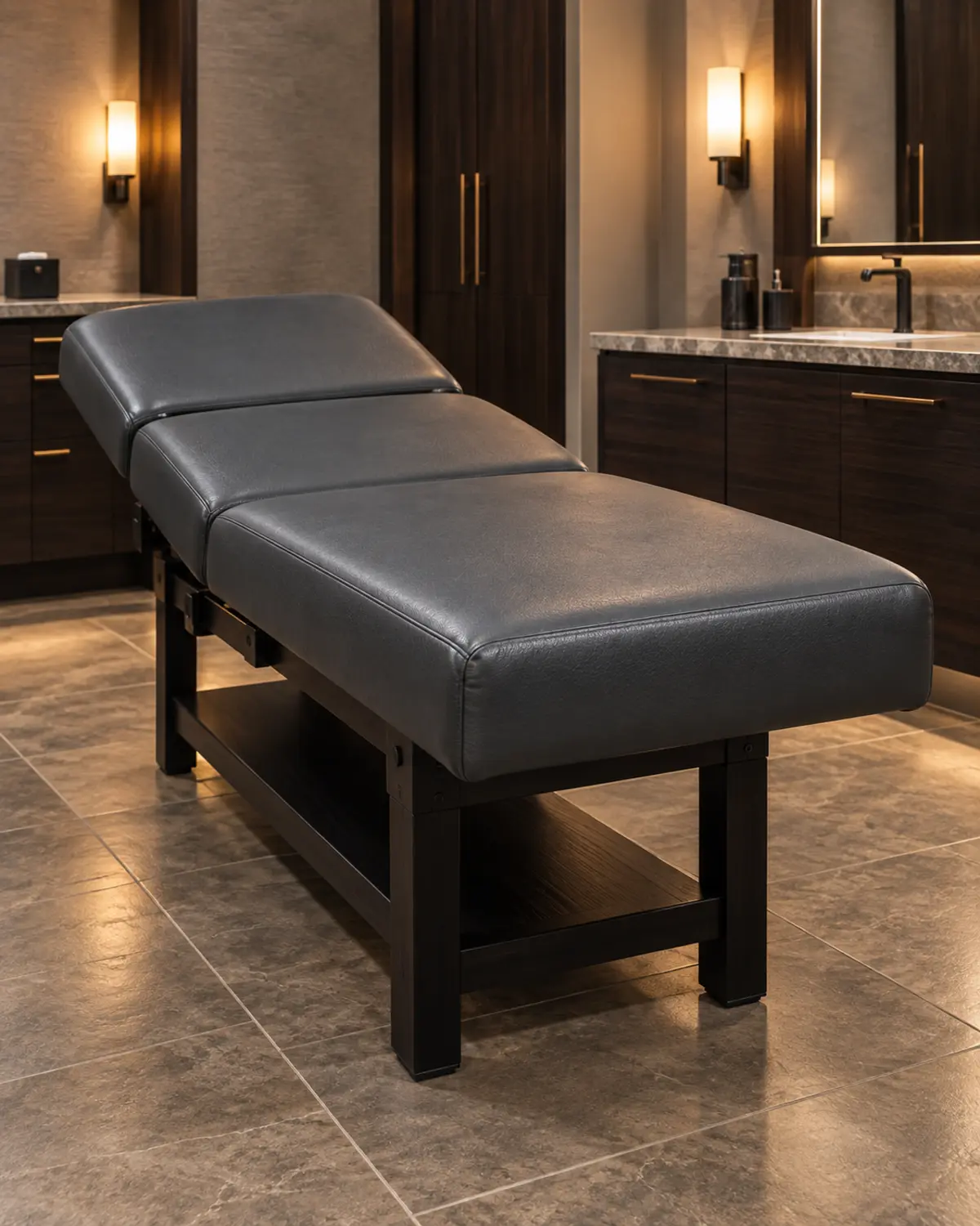 A charcoal massage table on a dark wood base