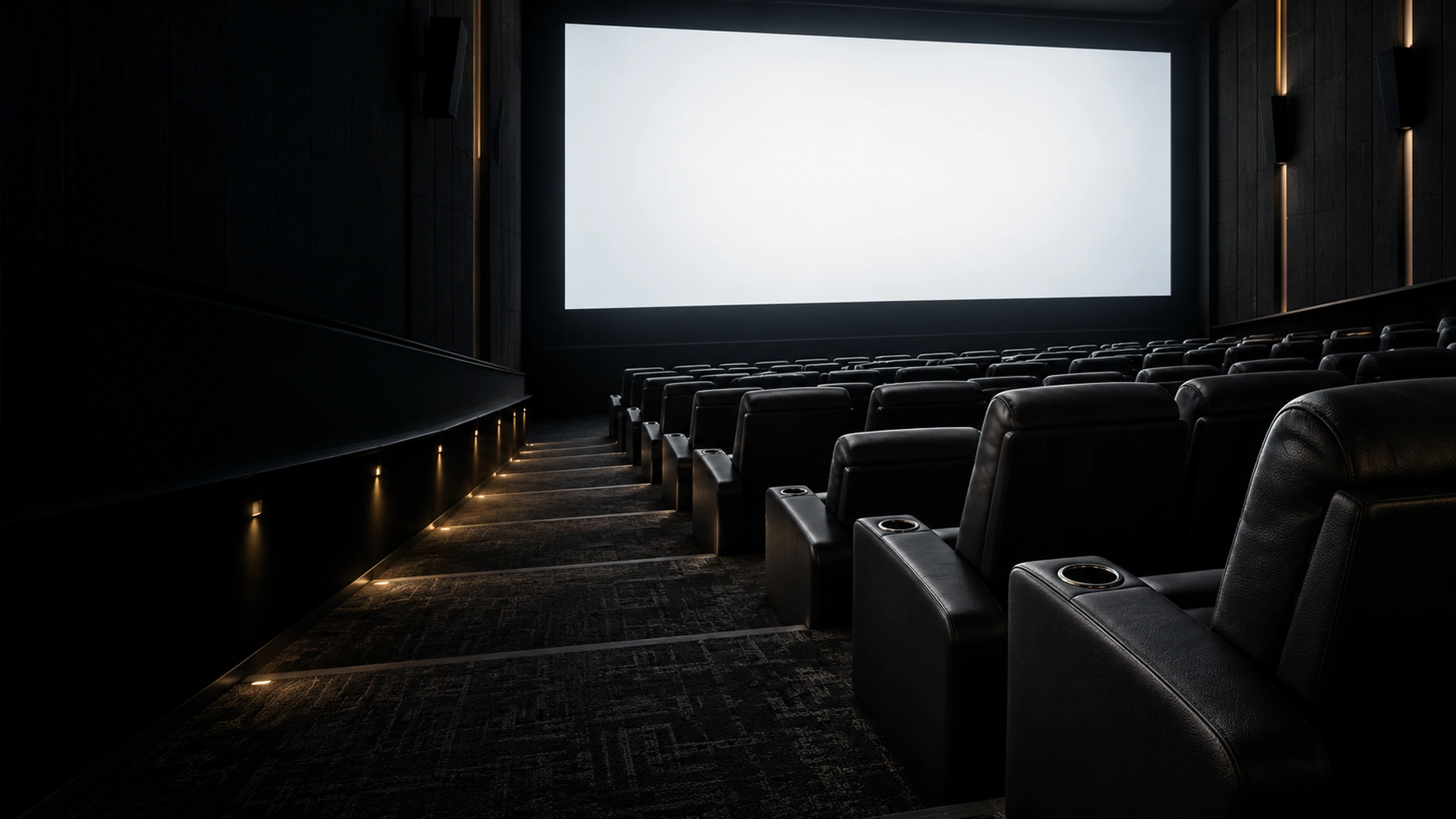 An empty cinema auditorium lit only by the glow of the screen