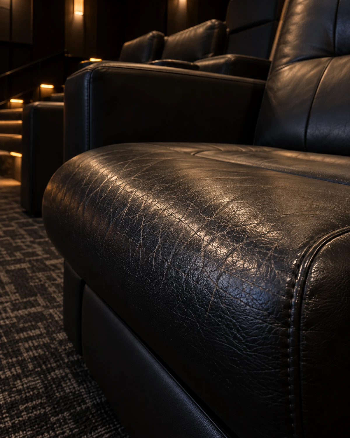 The worn front edge of a cinema recliner seat cushion