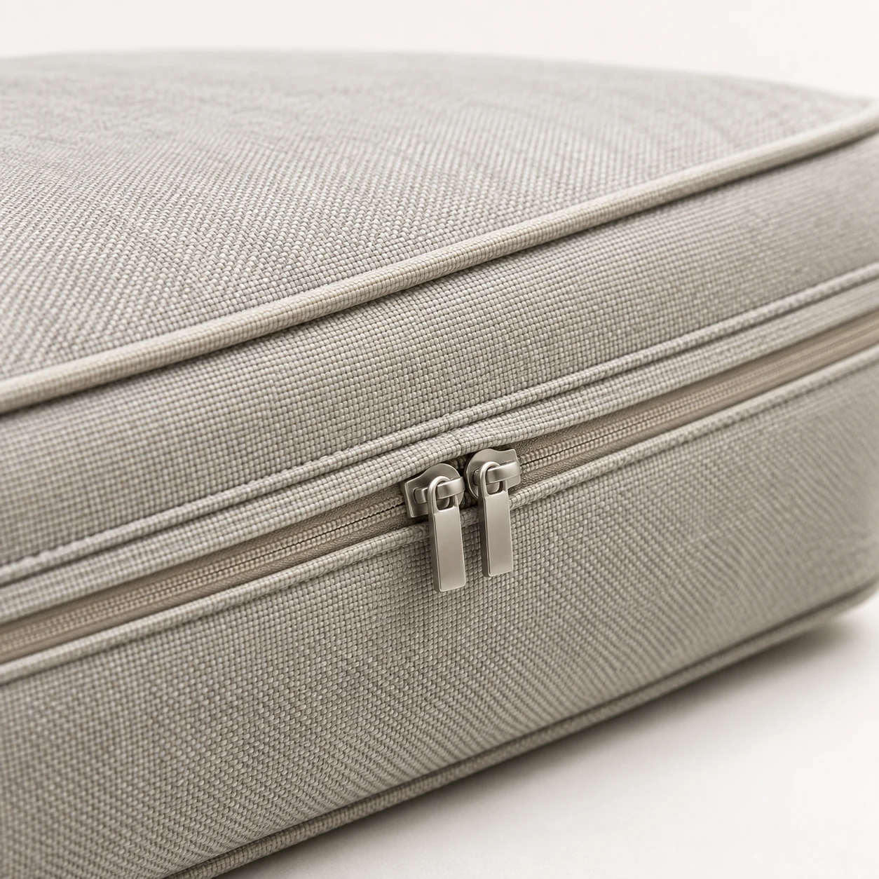 Closed zipper running along the back edge of a beige outdoor seat cushion