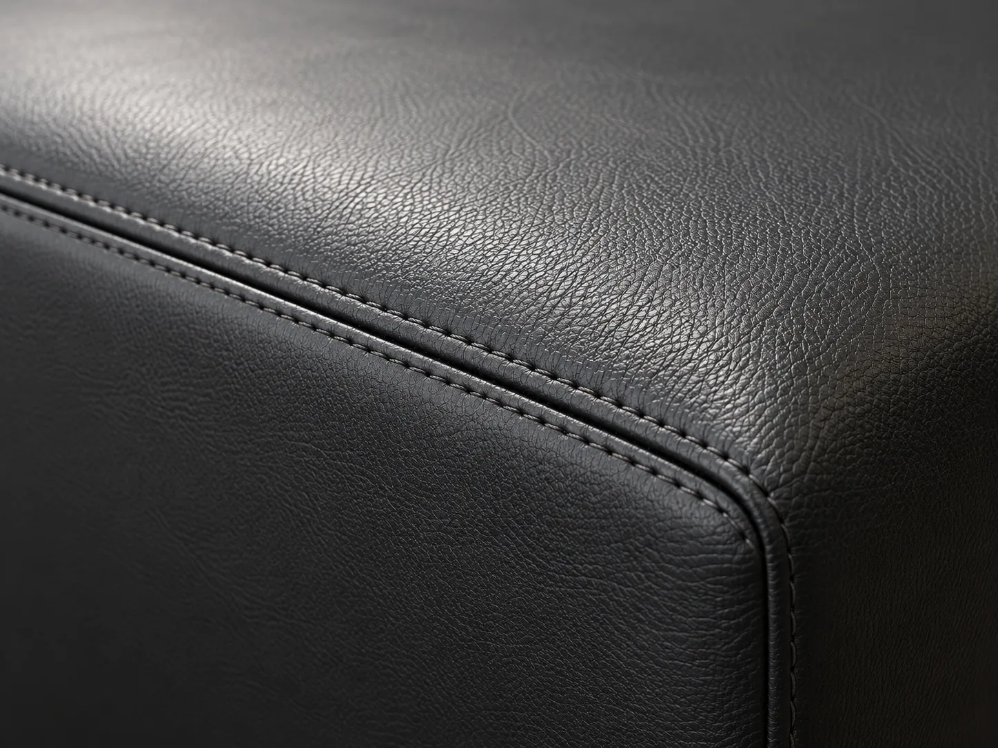 A close-up of black commercial vinyl with a stitched seam