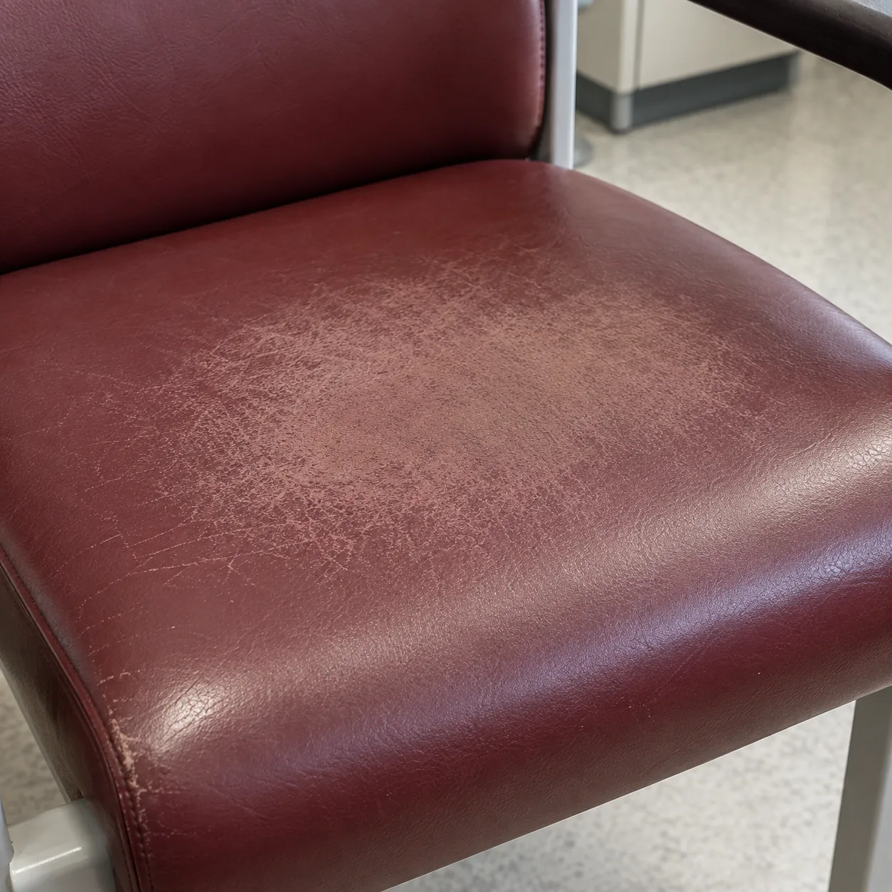 A burgundy vinyl seat with faded, uneven color