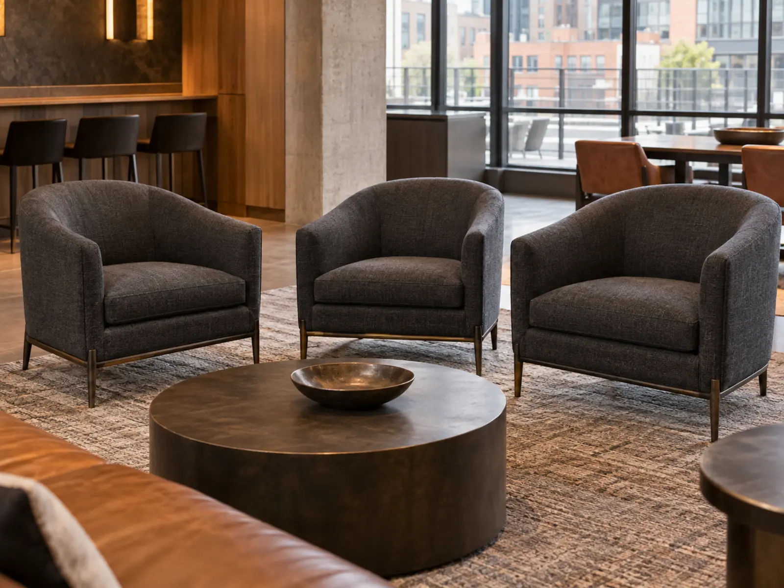Three charcoal fabric lounge chairs in a building amenity space