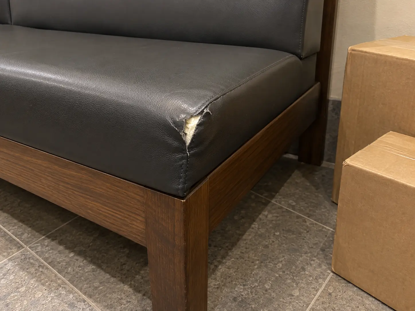 A torn corner on a common area bench seat