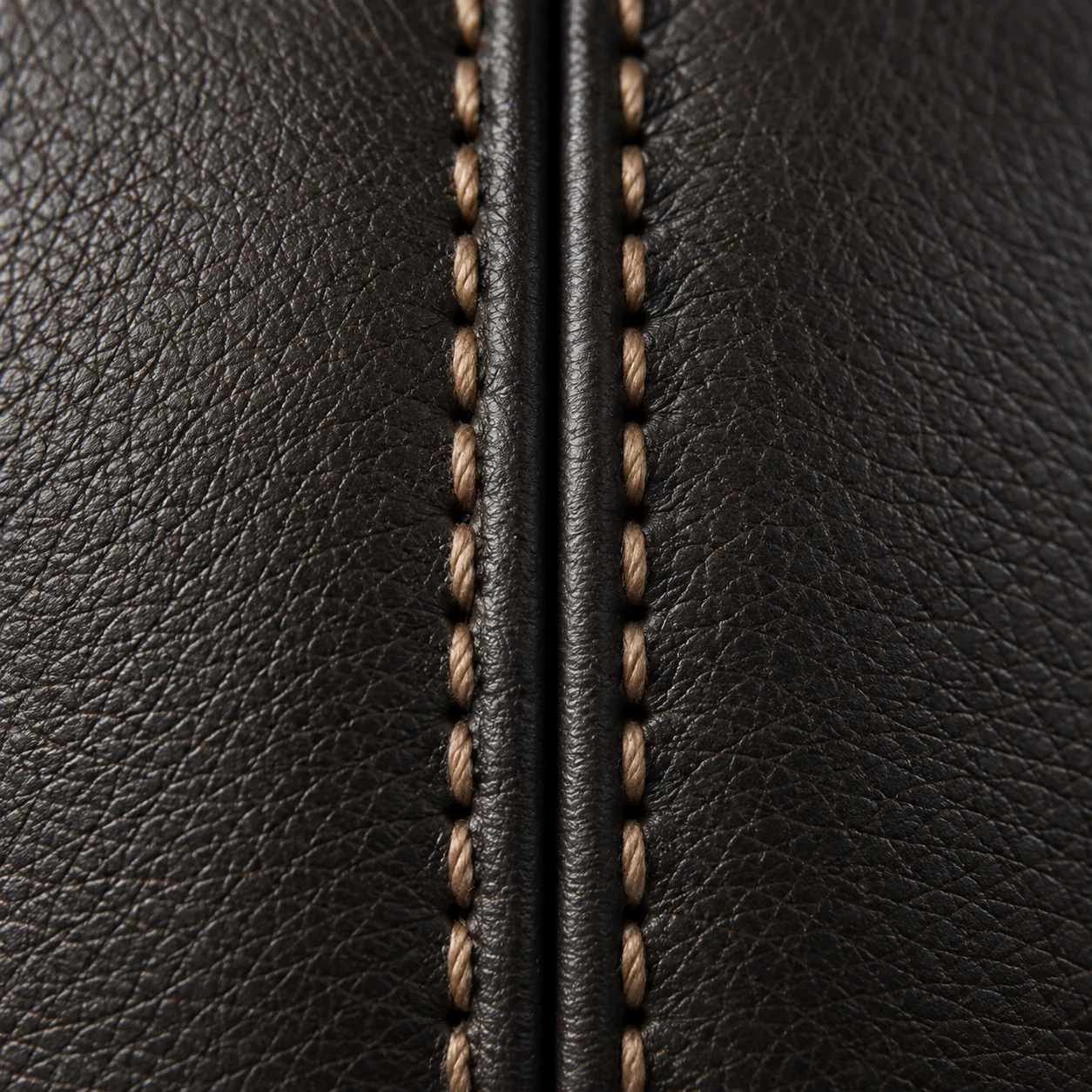 A center welt on dark brown leather with tan contrast saddle stitching either side