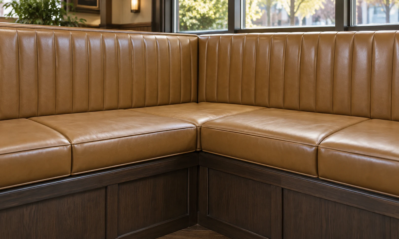Corner banquette seat cushions in tan leather after rebuilding in place
