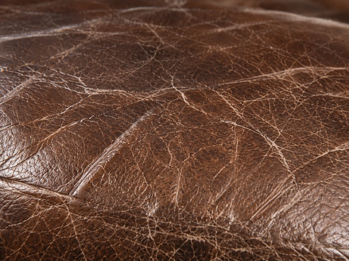 Bench reupholstery: brown bench leather crazed into a dense network of surface cracks