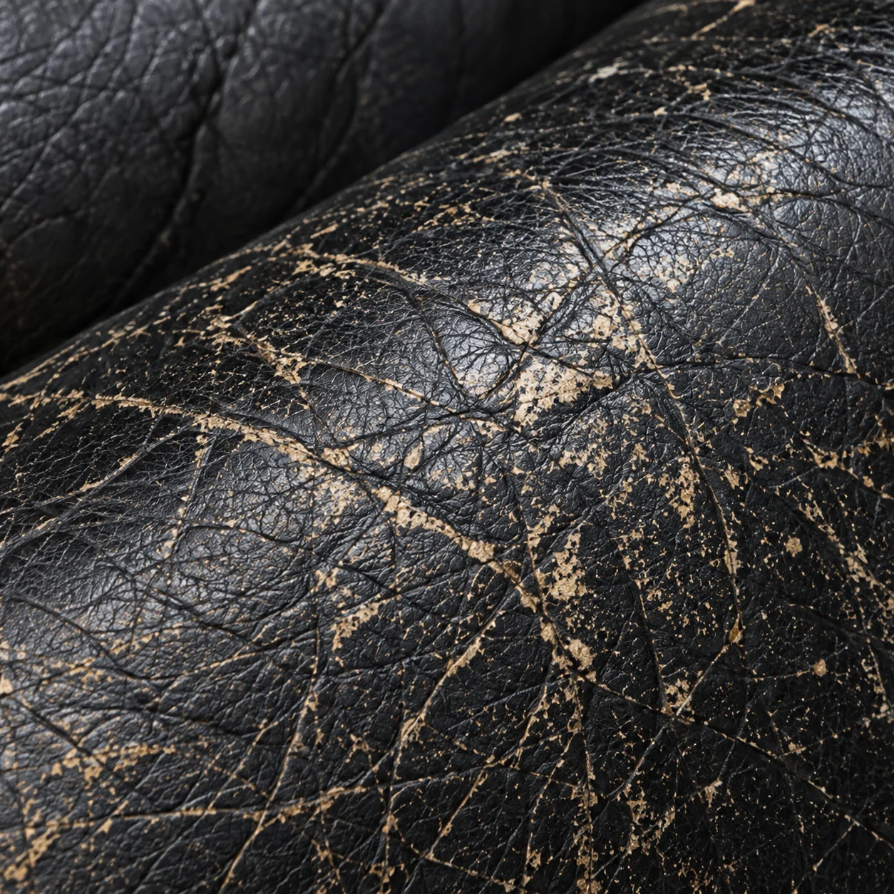 Crazed black leather showing tan underneath