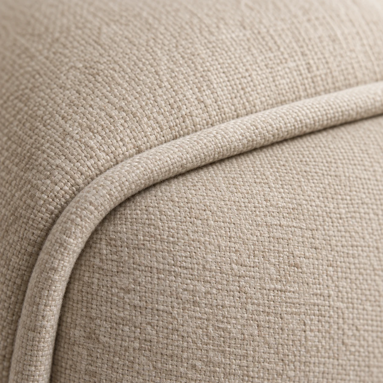 Cream linen chair corner with self-piping running around the curve