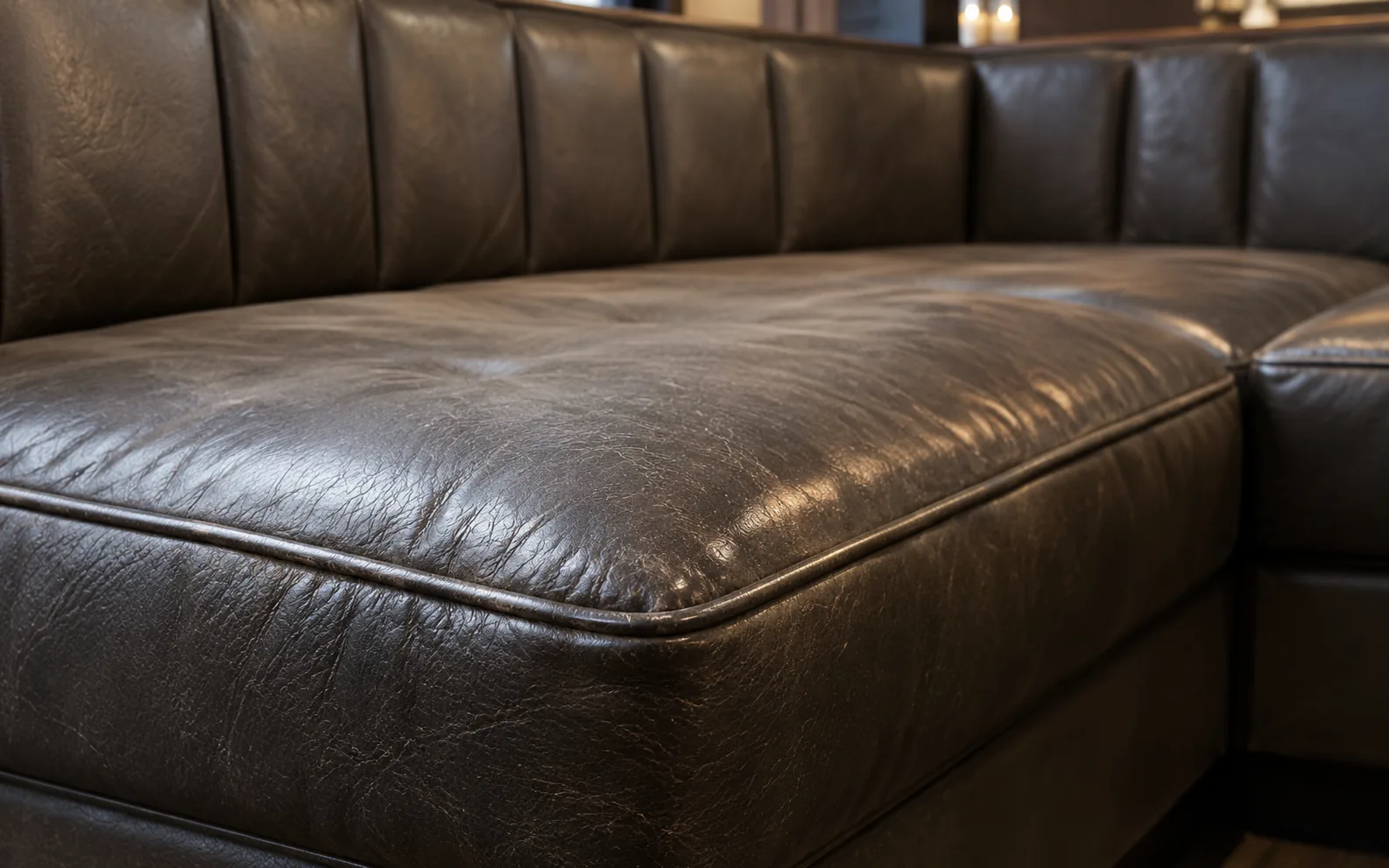 Creased, aged dark leather on a booth seat deck