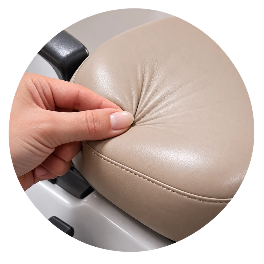 A technician pressing a dental chair headrest to check the vinyl and foam