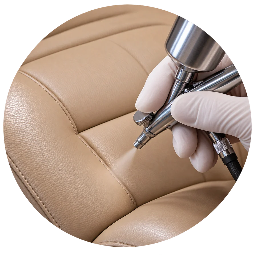An airbrush recoloring the taupe vinyl of a dental chair