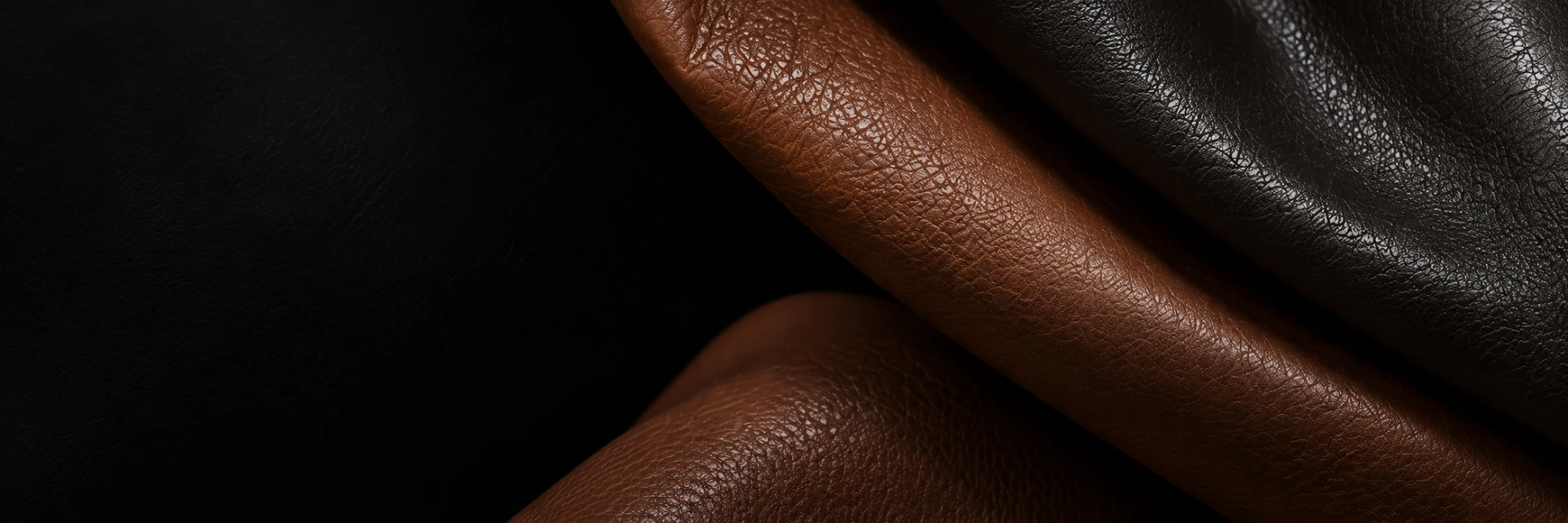 Two brown leather hides under one raking light