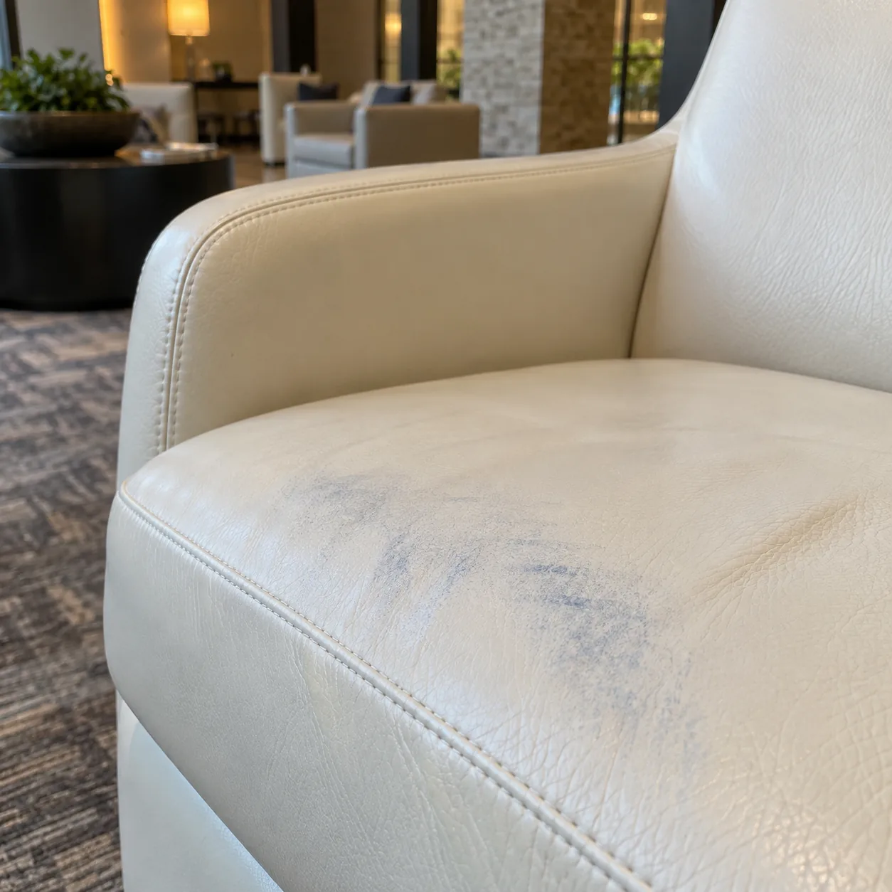 Blue dye transfer from clothing on a pale leather lobby seat